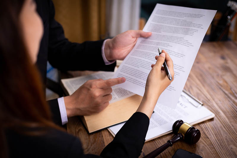 06 Un cliente consultando la firma de un documento con una jueza