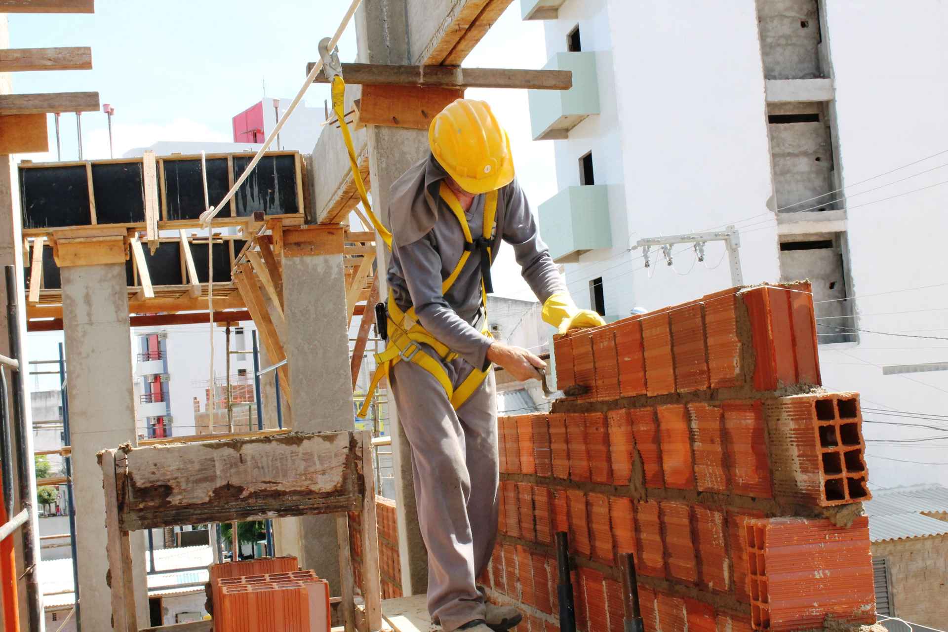 Sistemas constructivos tradicionales_Un trabajador de la construccion levantando una pared con bloques huecos de ceramica