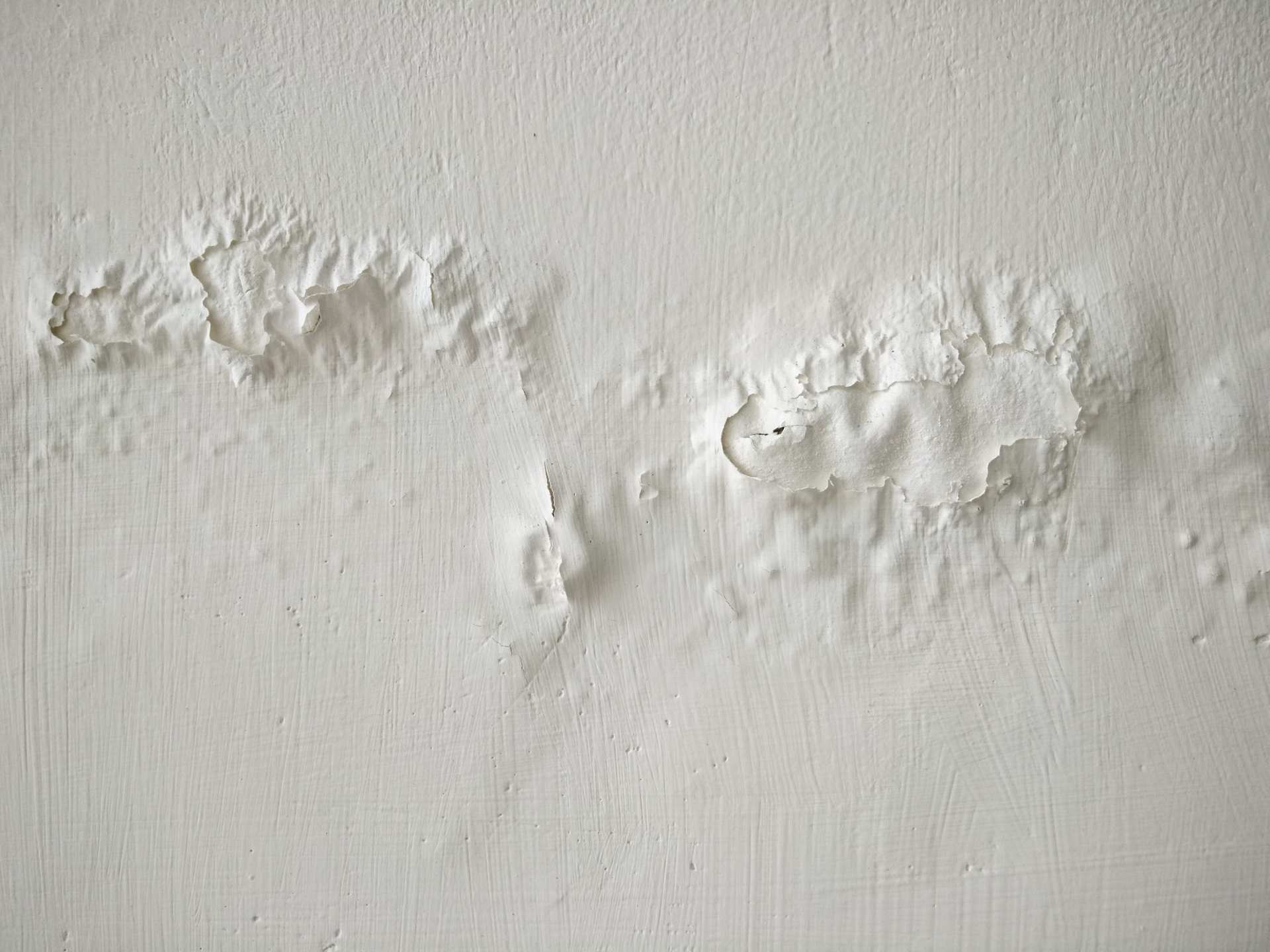 Una pared blanca deteriorada debido a humedad por filtracion