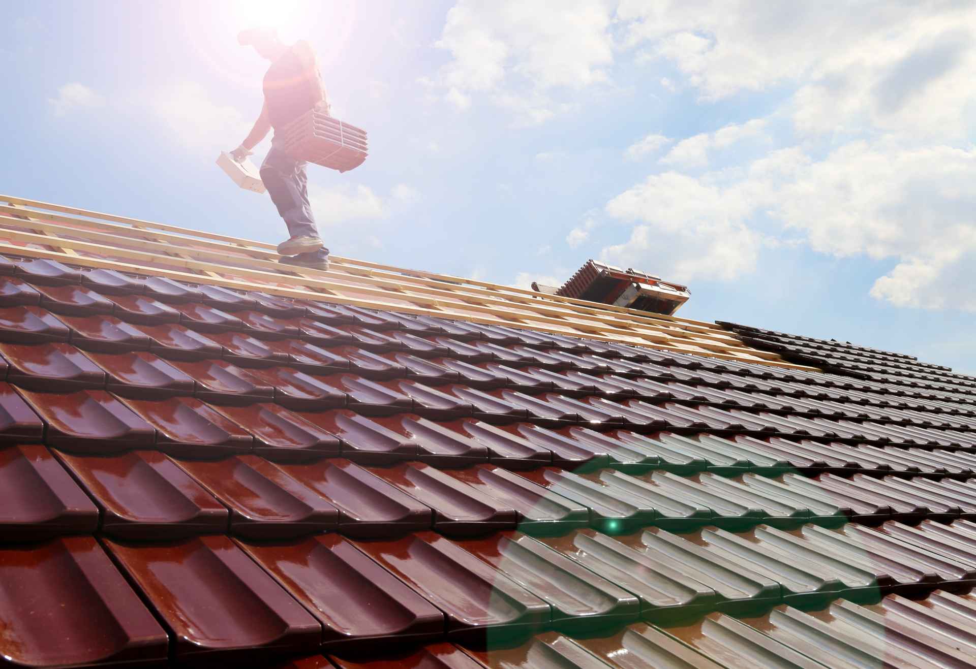 Como impermeabilizar techos de madera_Un trabajador colocando tejas de tegola